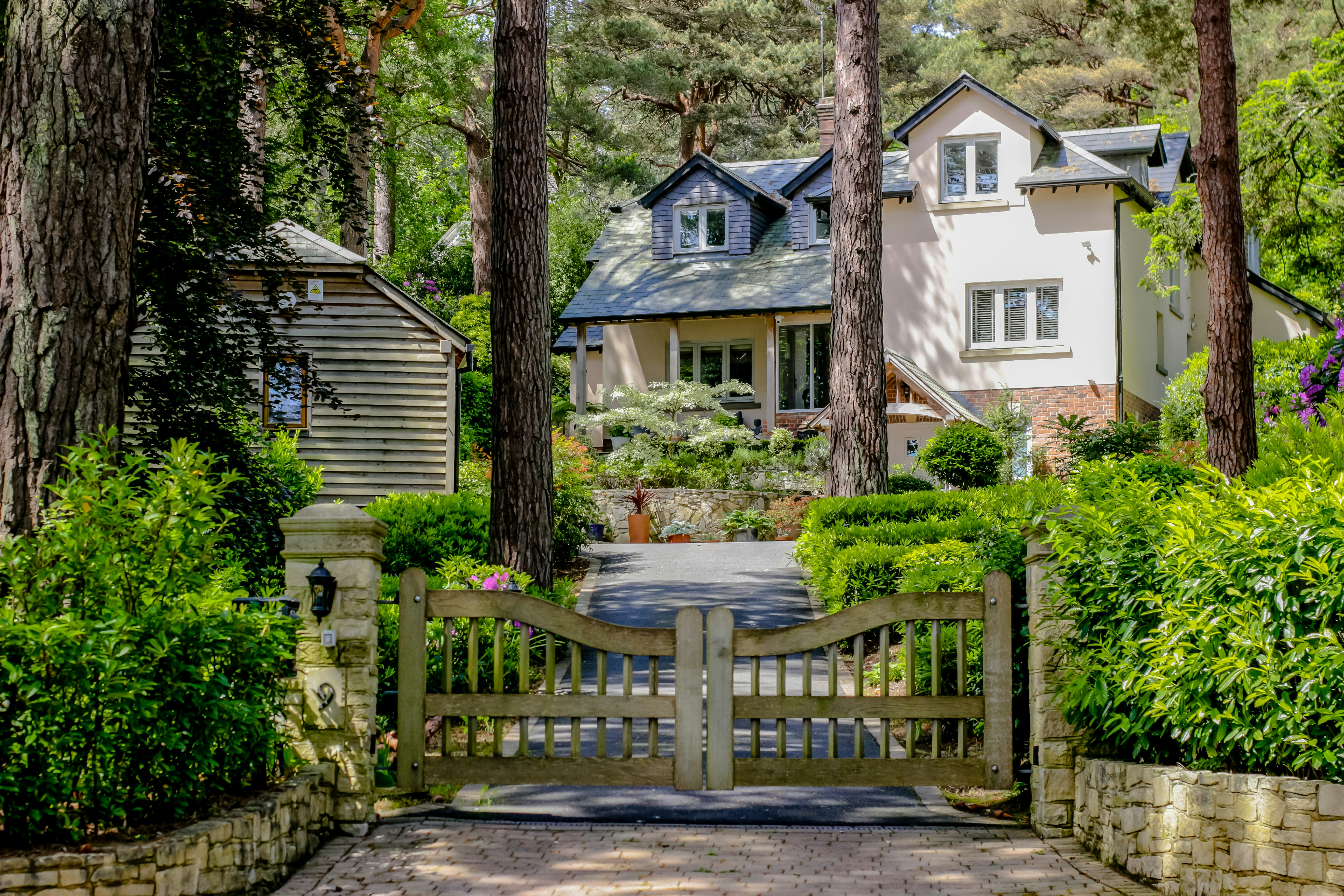 A house set back behind a wooden gate among pines