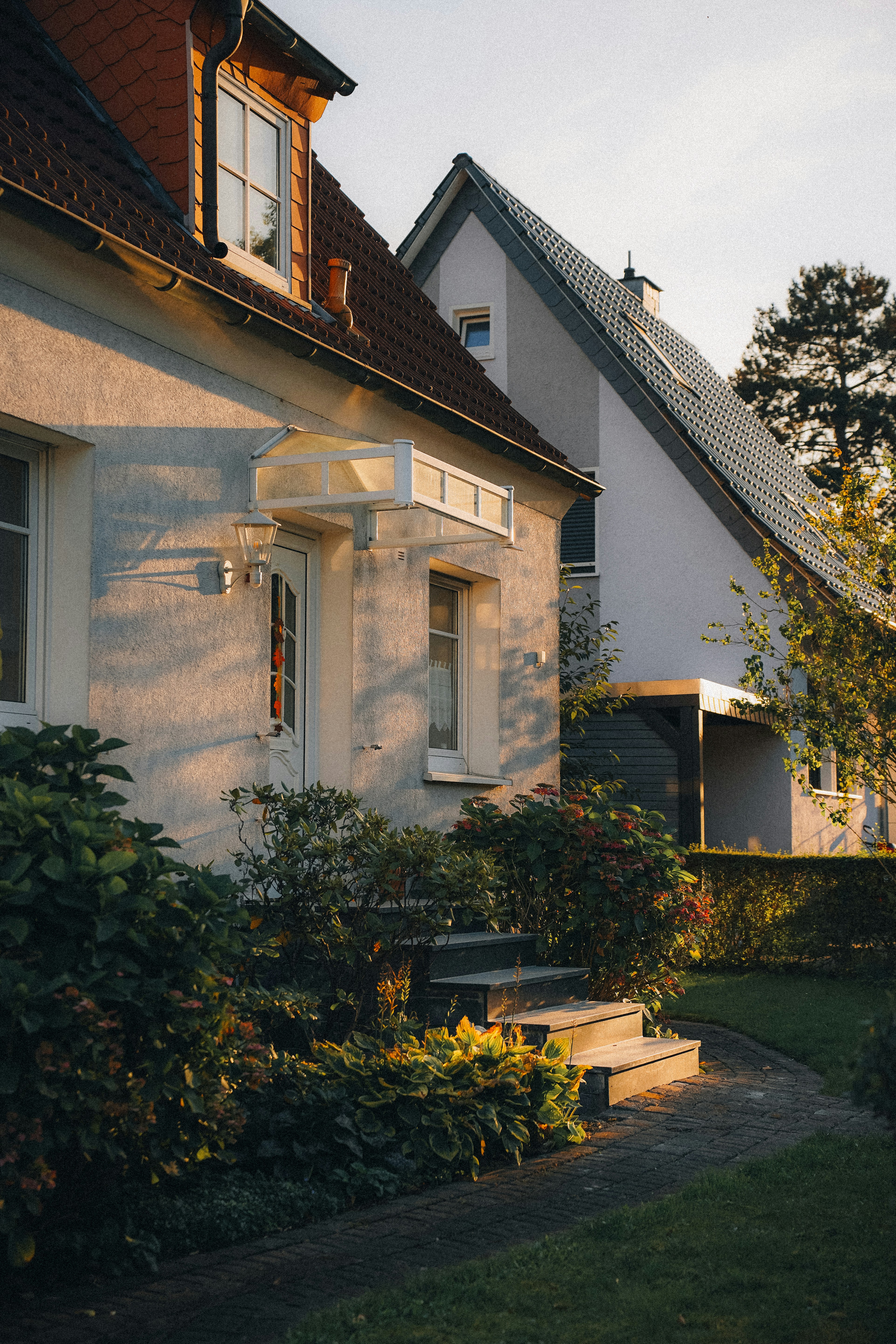 A house at golden hour, front steps and garden in late sun