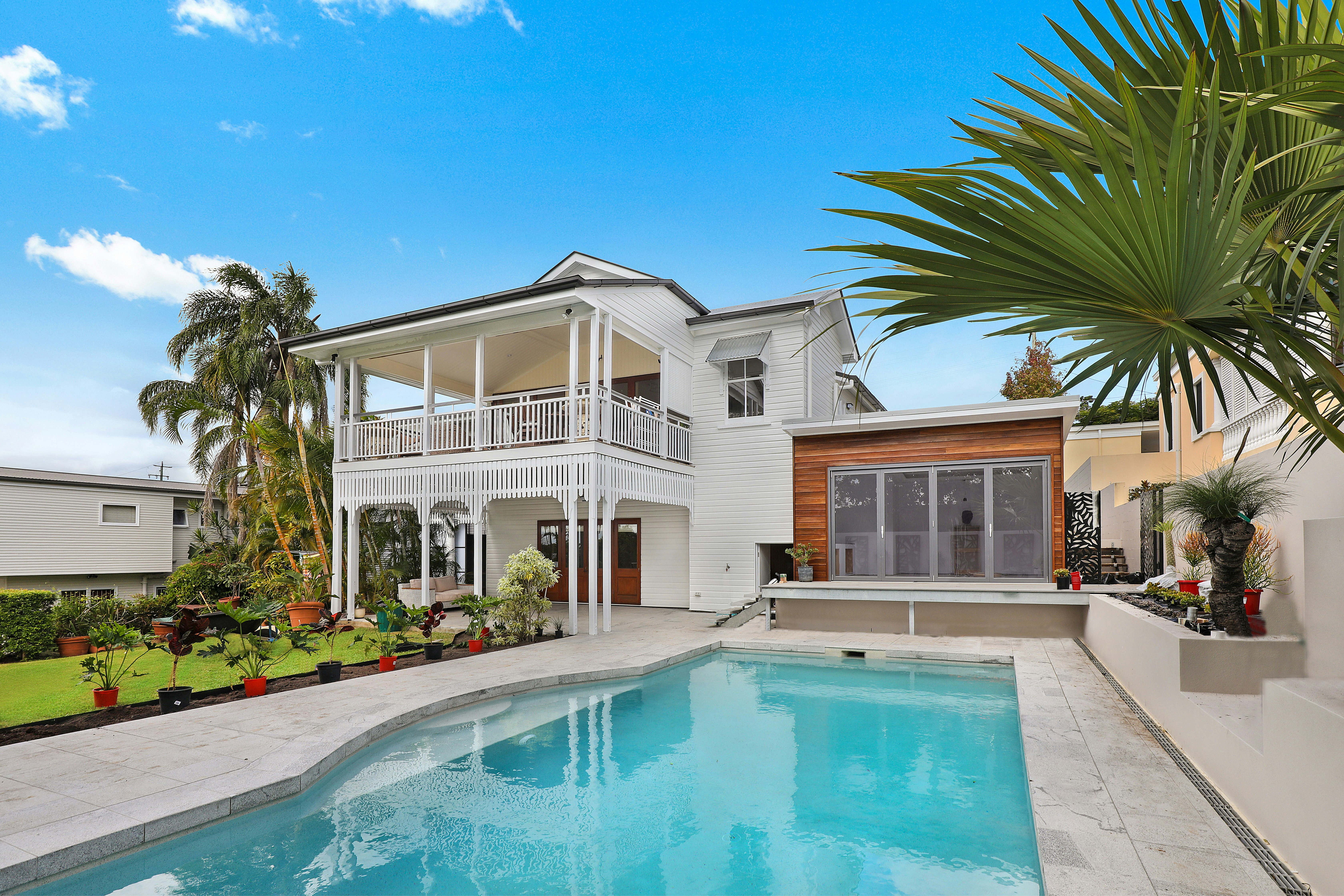 A weatherboard house and pool in the afternoon